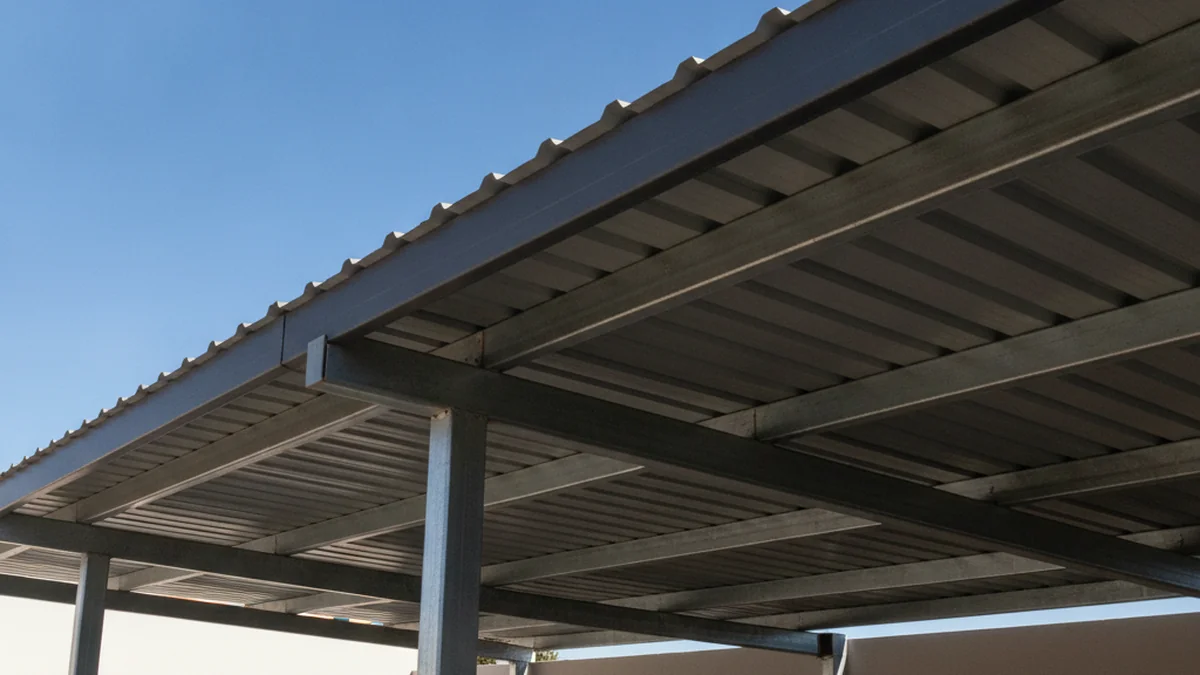 Close detail of a charcoal IBR steel carport roof and galvanised steel support posts in bright sun
